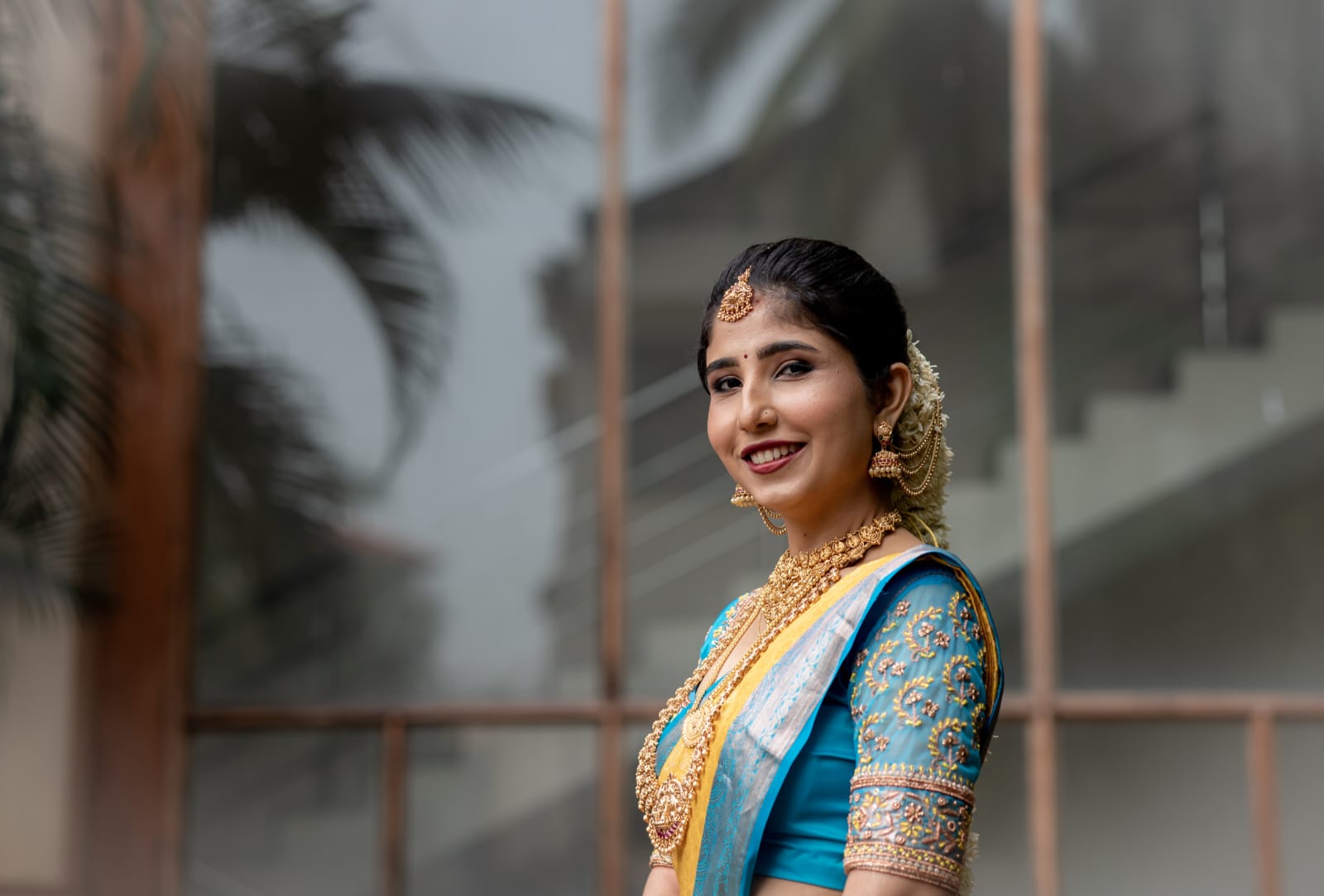 Stunning bridal portrait in blue and gold saree with traditional jewelry