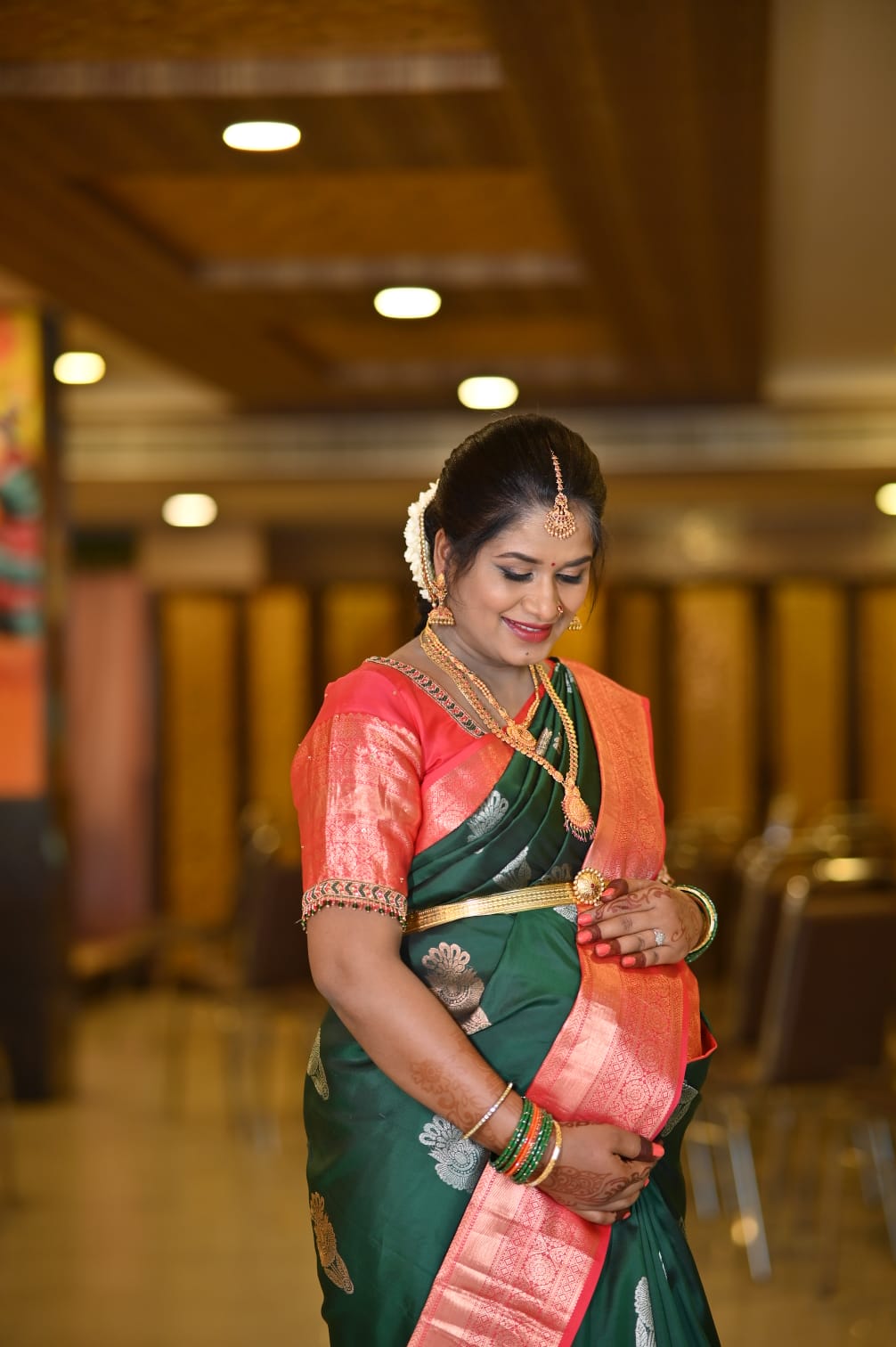 Beautiful bride in green and coral saree with traditional makeup