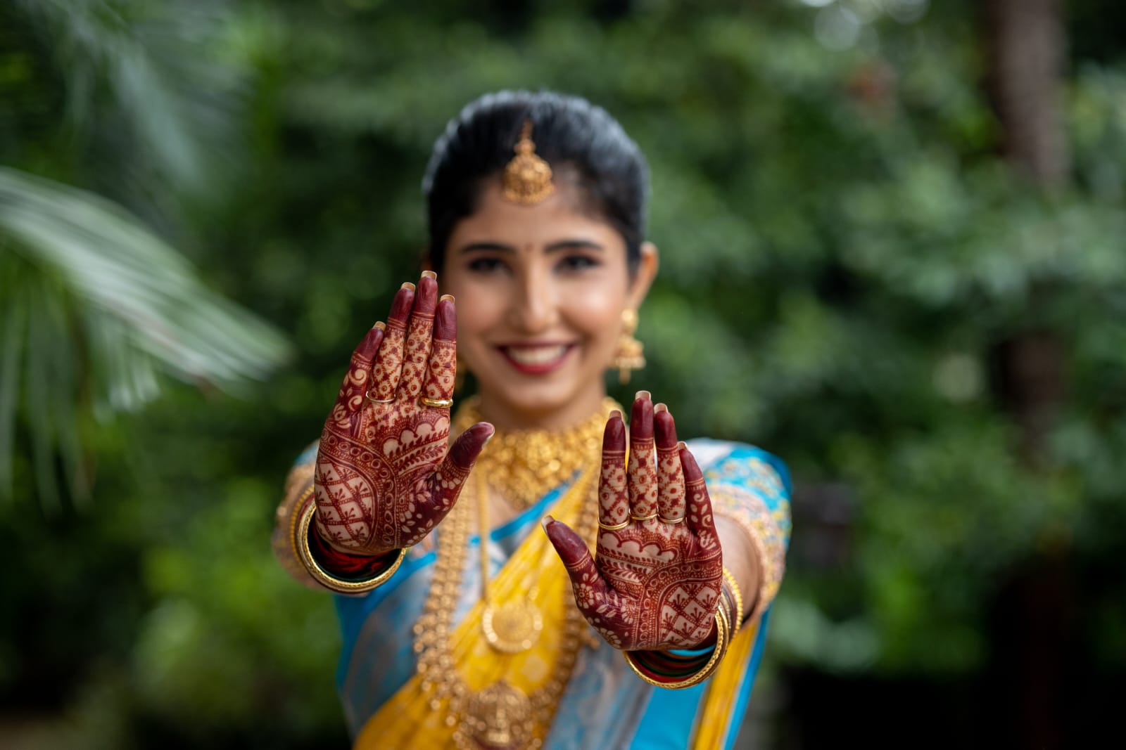 Bride displaying intricate henna designs with perfect bridal makeup